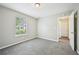 This bedroom has gray walls, and gray carpet and offers ample natural light at 1147 Saint Phillips Ct, Locust Grove, GA 30248