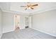 Bedroom featuring plush carpet, a ceiling fan, and two doorways at 1147 Saint Phillips Ct, Locust Grove, GA 30248