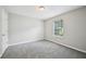 This empty bedroom features a neutral color scheme and plush gray carpeting at 1147 Saint Phillips Ct, Locust Grove, GA 30248