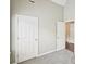 Bedroom features neutral walls, plush carpet, and double closets at 1147 Saint Phillips Ct, Locust Grove, GA 30248