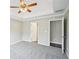 Bedroom featuring plush carpet, a ceiling fan, and two doorways at 1147 Saint Phillips Ct, Locust Grove, GA 30248