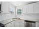 Close-up of the kitchen's stainless steel dishwasher, granite countertop, and white subway tile backsplash at 1147 Saint Phillips Ct, Locust Grove, GA 30248