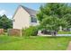 Grassy side yard with mature trees, and a partial view of the home's exterior at 1147 Saint Phillips Ct, Locust Grove, GA 30248