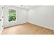 Bedroom featuring wood floors, bright white walls, and a window with backyard views at 3684 Clearbrooke Way, Duluth, GA 30097