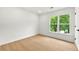 Bright bedroom showing wood floors, a new window with natural light and a white door at 3684 Clearbrooke Way, Duluth, GA 30097