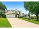 Elegant home boasts an expansive driveway, mature trees, manicured lawn and black trim at 3684 Clearbrooke Way, Duluth, GA 30097