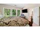 Bedroom with large windows, a television, and ensuite bathroom, offering a private retreat at 4161 Magnolia Glen Walk, Norcross, GA 30093