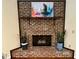 Close-up view of a brick fireplace, decorated with plants and colorful artwork above the mantle at 4323 Darwen Ct, Tucker, GA 30084