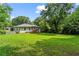 Expansive backyard with lush green grass, mature trees, and a charming patio at 629 Dunton Se Cir, Smyrna, GA 30082