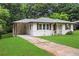 Charming single-story home featuring white siding, a well-manicured lawn, and a covered carport on a tree-lined street at 629 Dunton Se Cir, Smyrna, GA 30082
