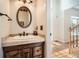 Bathroom featuring a vanity with granite countertop, decorative mirror, and neutral colored walls at 750 Gates Ln, Alpharetta, GA 30022
