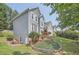 View of home featuring landscaped yard, small patio, basement entrance, and mature trees at 750 Gates Ln, Alpharetta, GA 30022