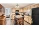 Well-lit kitchen featuring an island, light cabinets, black appliances, and tile flooring at 750 Gates Ln, Alpharetta, GA 30022