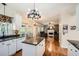 Open kitchen with white cabinetry, granite countertops, hardwood floors, and modern lighting at 750 Gates Ln, Alpharetta, GA 30022