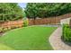 Green lawn, wooden fence, and brick-paved path create a welcoming backyard at 435 Ruby Forest Pkwy, Suwanee, GA 30024