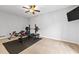 Neutral bedroom featuring ceiling fan, weight-lifting equipment, and a wall-mounted television at 435 Ruby Forest Pkwy, Suwanee, GA 30024
