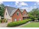 Aerial view of a brick home with a well-manicured lawn, detached garage, and mature landscaping at 435 Ruby Forest Pkwy, Suwanee, GA 30024