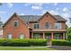 Charming brick home featuring well-maintained landscaping and inviting covered front porch with classic shutters at 435 Ruby Forest Pkwy, Suwanee, GA 30024