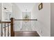 Hallway with hardwood floors, wrought iron railing, and decorative chandelier at 435 Ruby Forest Pkwy, Suwanee, GA 30024