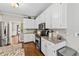 Charming kitchen showcases white cabinets, granite countertops, stainless steel appliances, and hardwood flooring at 435 Ruby Forest Pkwy, Suwanee, GA 30024