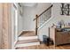 Staircase with wooden steps and wrought iron railing, with a console table and artwork visible at 435 Ruby Forest Pkwy, Suwanee, GA 30024