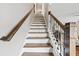Staircase with wooden steps, white risers, and wrought iron railing leading upwards at 435 Ruby Forest Pkwy, Suwanee, GA 30024