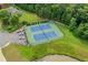 Aerial view showcases community tennis courts with four cars parked nearby at 435 Ruby Forest Pkwy, Suwanee, GA 30024