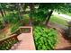 Wooden stairs lead down to a private backyard surrounded by lush greenery and mature trees at 50 Worthington Dr, Villa Rica, GA 30180