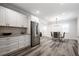 Open kitchen and dining area with stainless steel appliances, white cabinets, and modern lighting at 872 Beryl Sw St, Atlanta, GA 30310