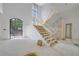 Spacious two-story foyer featuring a light-filled interior with a stone accent wall and open staircase at 120 Wood River Ct, Johns Creek, GA 30097