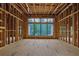 Unfinished living room featuring exposed framing, large windows, and high ceilings, awaiting customization at 120 Wood River Ct, Johns Creek, GA 30097