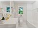 Bathroom with white cabinets, gold fixtures, and a window with a view at 1995 Venetian Sw Dr, Atlanta, GA 30311
