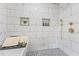 Bright bathroom featuring marble tile, shower niche, and gold fixtures at 1995 Venetian Sw Dr, Atlanta, GA 30311