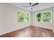 Bedroom with ceiling fan, hardwood floors, and two large windows with outdoor view at 1995 Venetian Sw Dr, Atlanta, GA 30311