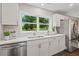 Updated kitchen with white cabinets, stainless steel appliances, and a view of the front yard through the window at 1995 Venetian Sw Dr, Atlanta, GA 30311