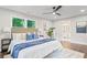 Bright main bedroom with a ceiling fan, hardwood floors, and a large bed with blue and white bedding at 1995 Venetian Sw Dr, Atlanta, GA 30311