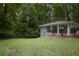 View of the home's lush, green backyard, framed by mature trees at 2383 Edgewater Sw Dr, Atlanta, GA 30311