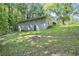 Spacious backyard view of a two-story home with a lush green lawn surrounded by mature trees at 2383 Edgewater Sw Dr, Atlanta, GA 30311