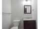 Bathroom featuring dark wood vanity, framed mirror, and toilet at 2383 Edgewater Sw Dr, Atlanta, GA 30311