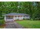 Charming single-story home with a covered carport, landscaped front yard, and red front door at 2383 Edgewater Sw Dr, Atlanta, GA 30311