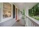Inviting front porch featuring a red front door and view of landscaped yard at 2383 Edgewater Sw Dr, Atlanta, GA 30311