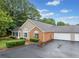 Exterior view of a well maintained brick house with lush landscaping, a garage and a driveway at 4512 Orchard Trce, Roswell, GA 30076