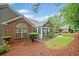 Exterior view of a well maintained single story brick house with a sunroom, lush landscaping and a sidewalk at 4512 Orchard Trce, Roswell, GA 30076