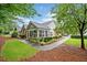 Exterior view of a well maintained single story house with sunroom, lush landscaping and a sidewalk at 4512 Orchard Trce, Roswell, GA 30076