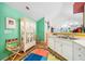 Bright kitchen with white cabinets and appliances, featuring colorful accents and open layout to dining area at 4512 Orchard Trce, Roswell, GA 30076