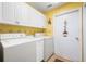 This laundry room has a washer, dryer, and storage cabinets at 4512 Orchard Trce, Roswell, GA 30076