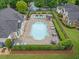 Aerial view of a community pool with lounge chairs, tables, manicured hedges and a black fence at 4512 Orchard Trce, Roswell, GA 30076