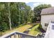 A view of the backyard highlighting the lush greenery, manicured lawn, and bordering trees from the home's deck at 9360 Nesbit Lakes Dr, Alpharetta, GA 30022