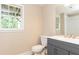 Bathroom features a vanity with shaker cabinets, framed mirror, and natural light at 9360 Nesbit Lakes Dr, Alpharetta, GA 30022