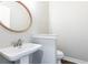 Powder room with vessel sink, round mirror, and pedestal sink at 9360 Nesbit Lakes Dr, Alpharetta, GA 30022